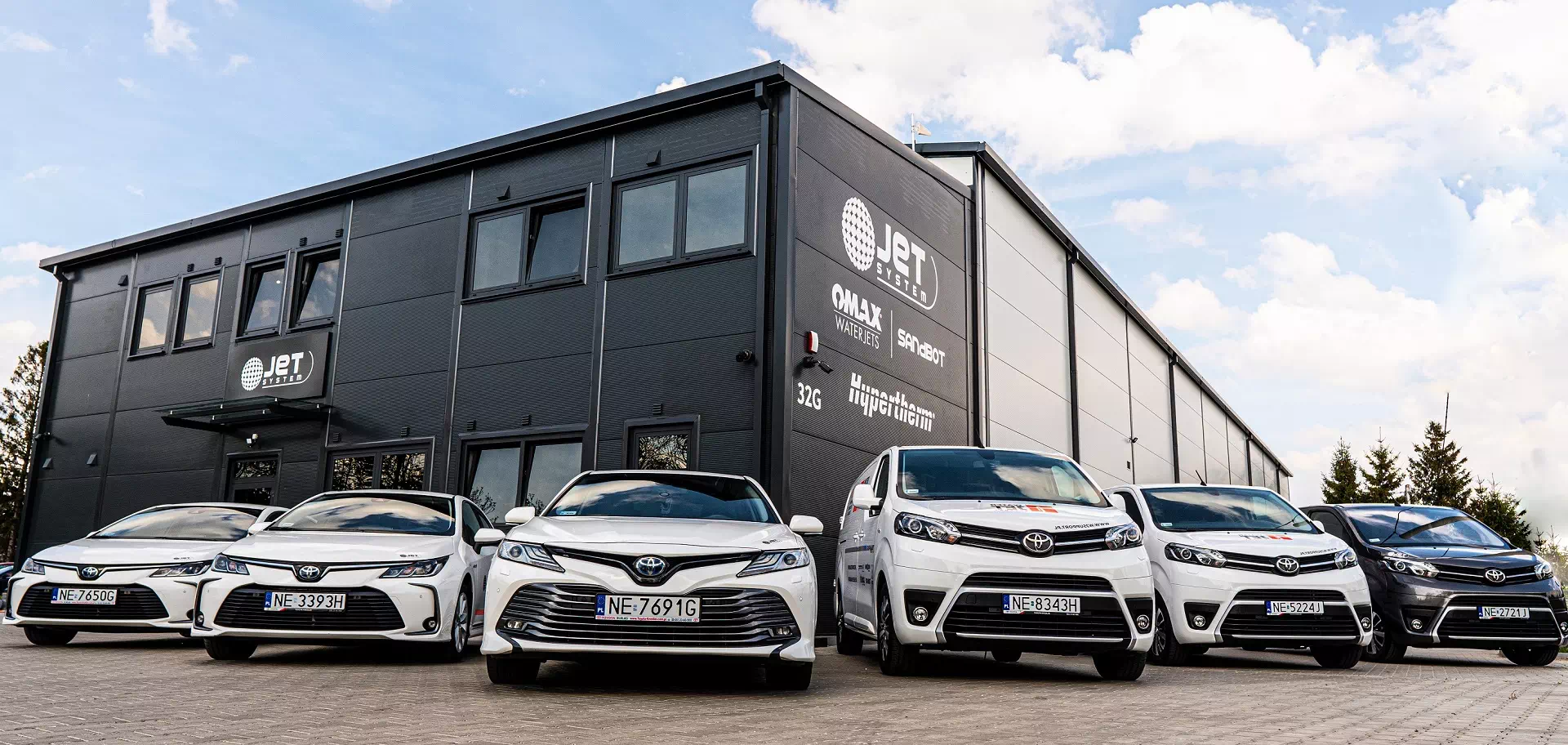 auta zaparkowane pod&nbsp;budynkiem firmowym